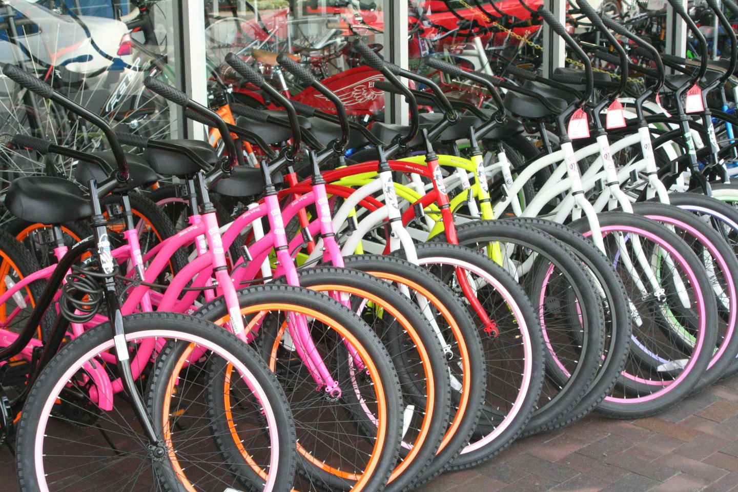Färgglada cyklar parkerade i en rad utanför en butik.